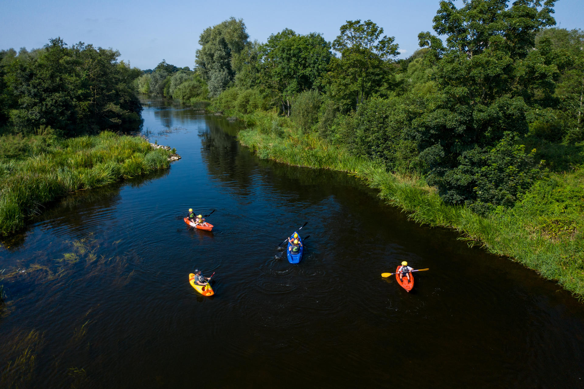 Aerial view of 4 people canoeing in a river.